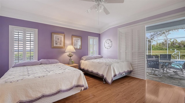 bedroom featuring ceiling fan, wood finished floors, crown molding, and access to exterior