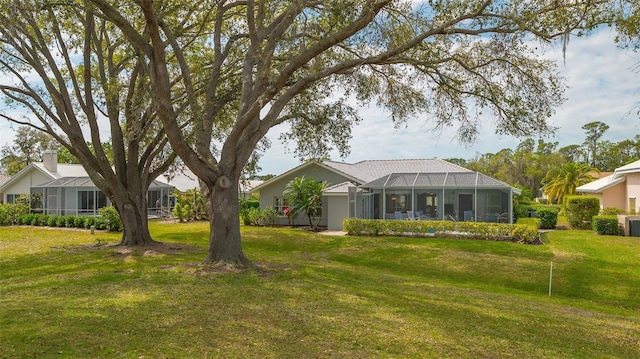 view of front of property with glass enclosure and a front yard