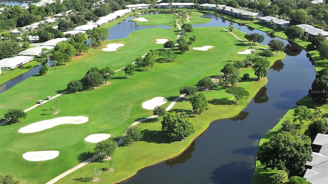 drone / aerial view featuring golf course view and a water view