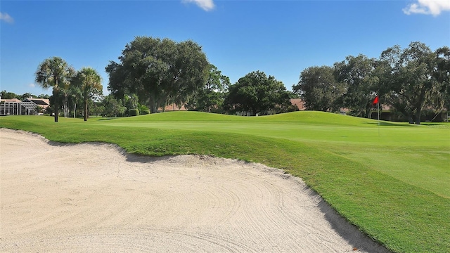 view of community with view of golf course and a lawn