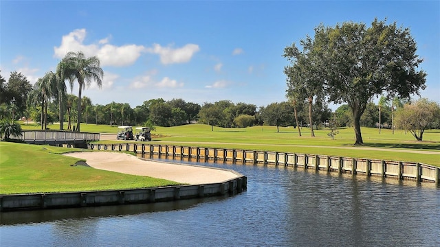 view of property's community featuring a yard, a water view, and golf course view