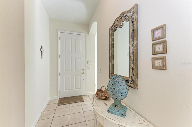 doorway featuring baseboards and light tile patterned flooring