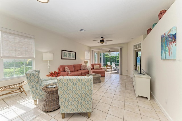 living area with light tile patterned floors, baseboards, visible vents, and ceiling fan