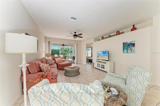 living room featuring visible vents, ceiling fan, baseboards, and light tile patterned floors