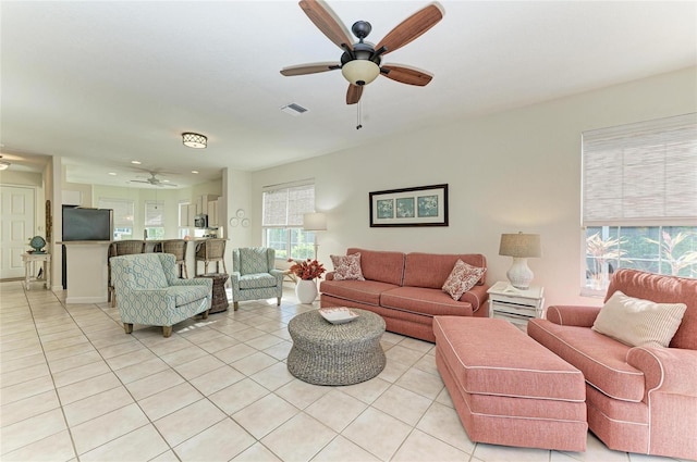 living room featuring visible vents, light tile patterned flooring, and a ceiling fan