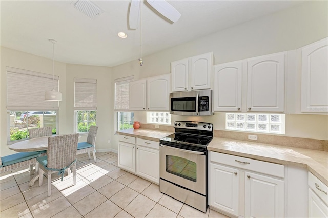 kitchen featuring hanging light fixtures, white cabinetry, stainless steel appliances, and light countertops