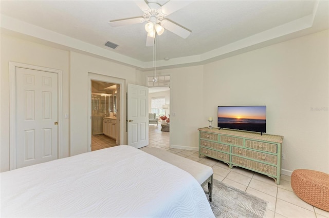 tiled bedroom featuring a raised ceiling, visible vents, and baseboards