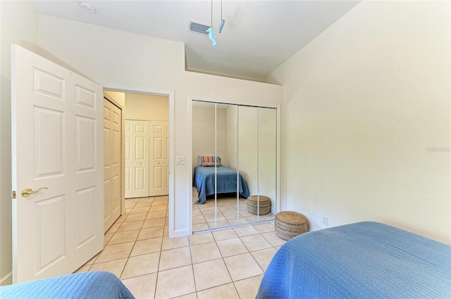 bedroom featuring a closet, light tile patterned flooring, and visible vents