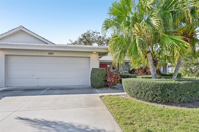 ranch-style home with a garage, driveway, and stucco siding