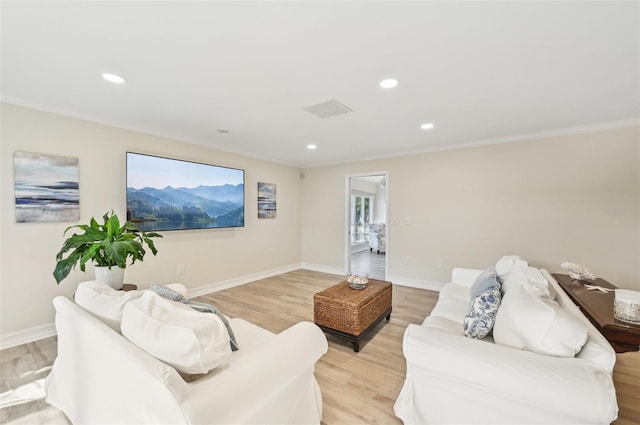 living area with recessed lighting, visible vents, light wood-style floors, ornamental molding, and baseboards