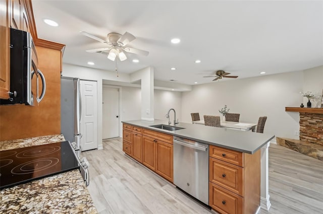 kitchen with ceiling fan, appliances with stainless steel finishes, light wood-type flooring, a sink, and recessed lighting