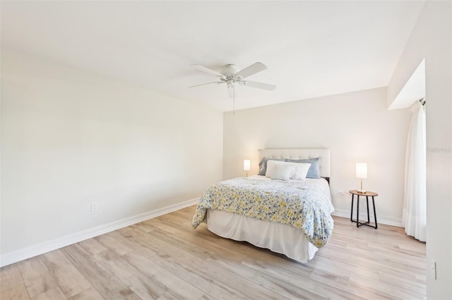 bedroom with light wood-style floors, ceiling fan, and baseboards