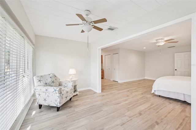 bedroom with light wood-type flooring, baseboards, visible vents, and a ceiling fan