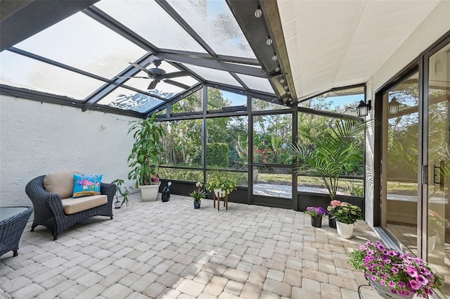 sunroom / solarium featuring vaulted ceiling with beams and a ceiling fan