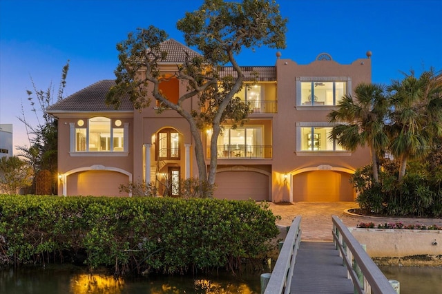 1364 Point Crisp Rd, Sarasota, FL 34242 - view of front of property featuring a garage, stucco siding, a tile roof, and a balcony
