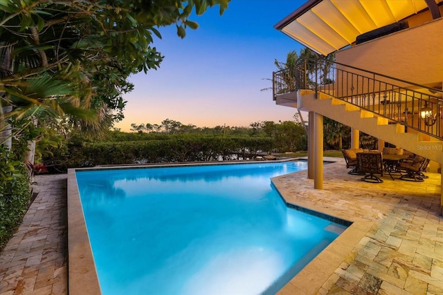 1364 Point Crisp Rd, Sarasota, FL 34242 - pool at dusk featuring a patio area, stairway, and an outdoor pool