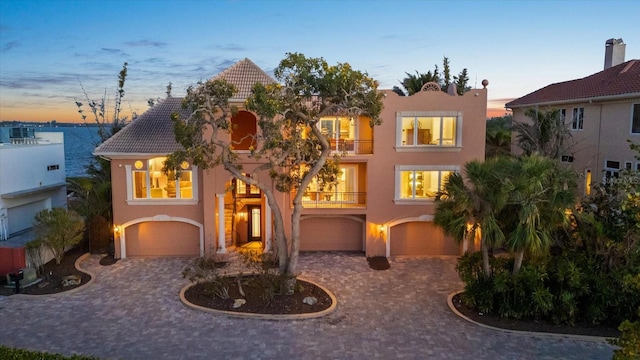 1364 Point Crisp Rd, Sarasota, FL 34242 - view of front facade with an attached garage, decorative driveway, a balcony, and stucco siding