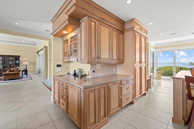 1364 Point Crisp Rd, Sarasota, FL 34242 - kitchen featuring glass insert cabinets, a sink, crown molding, light tile patterned flooring, and light stone counters