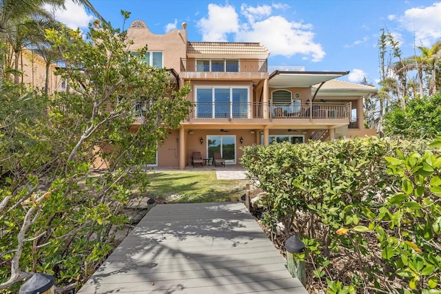 1364 Point Crisp Rd, Sarasota, FL 34242 - back of property with a patio area, a tile roof, a balcony, and stucco siding