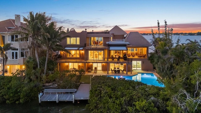 1364 Point Crisp Rd, Sarasota, FL 34242 - back of house featuring a tiled roof, a patio, stucco siding, an outdoor pool, and a balcony