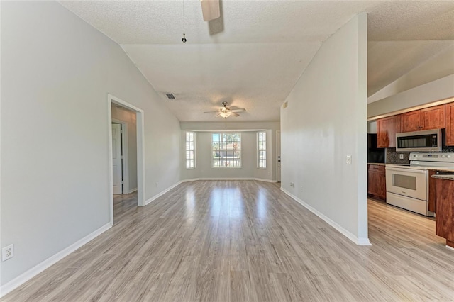 unfurnished living room featuring lofted ceiling, light wood-style floors, ceiling fan, a textured ceiling, and baseboards