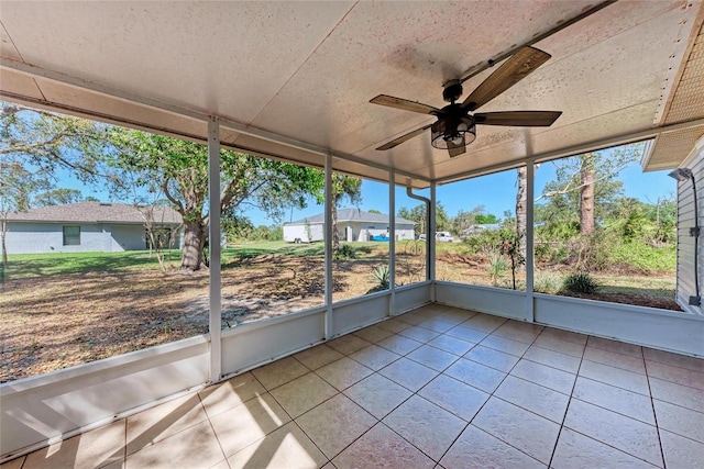 unfurnished sunroom featuring ceiling fan