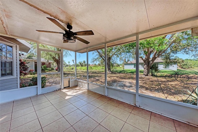 unfurnished sunroom with ceiling fan