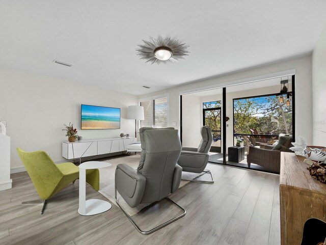 living area featuring visible vents and wood finished floors