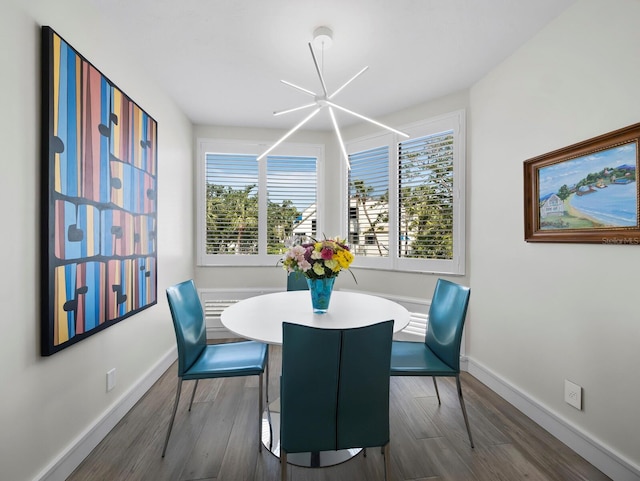 dining area with baseboards, an inviting chandelier, and dark wood-style flooring