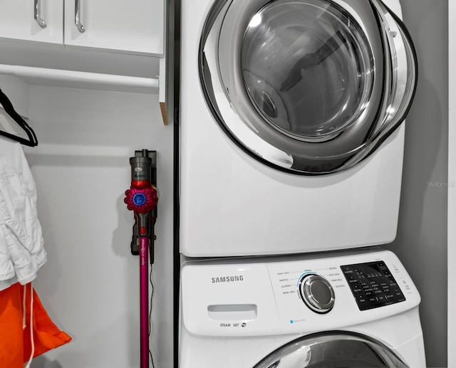 laundry area featuring cabinet space and stacked washing maching and dryer