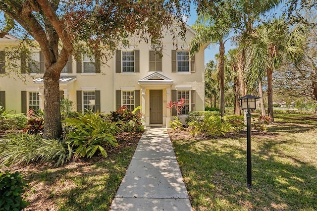 view of front of house with a front yard and stucco siding