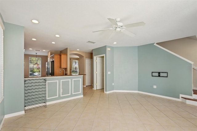 empty room featuring light tile patterned floors, stairs, and baseboards