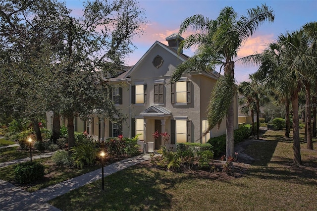 view of front of house featuring a lawn and stucco siding