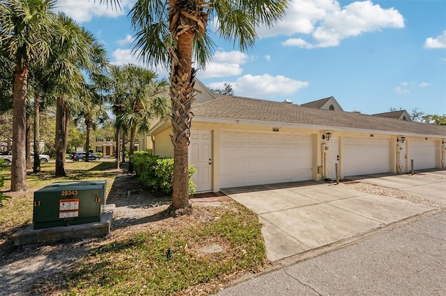 view of front of home with an attached garage, concrete driveway, and stucco siding