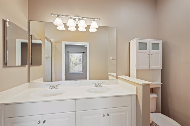 full bath with a sink, toilet, and double vanity