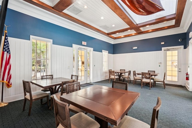 dining room featuring wainscoting, coffered ceiling, beamed ceiling, and french doors