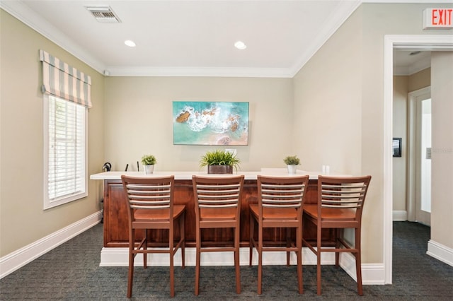 dining space with crown molding, visible vents, dark carpet, and baseboards