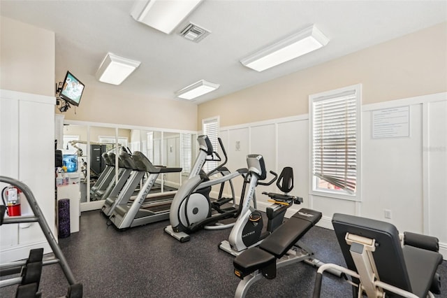 gym with wainscoting, visible vents, and a decorative wall