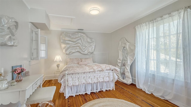 7715 Westmoreland Dr, Sarasota, FL 34243 - bedroom with attic access, wood finished floors, and baseboards