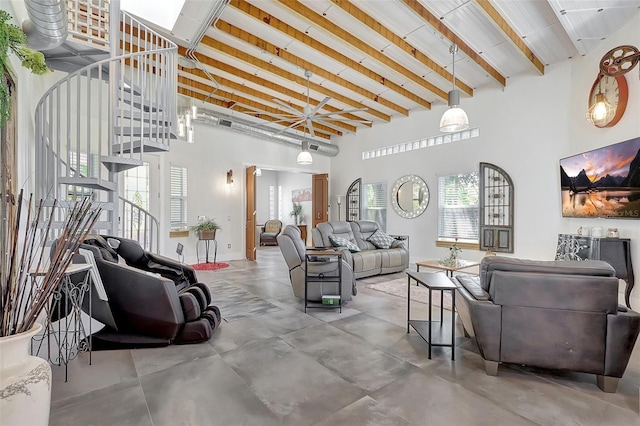 living area with stairway, a high ceiling, concrete flooring, beam ceiling, and baseboards