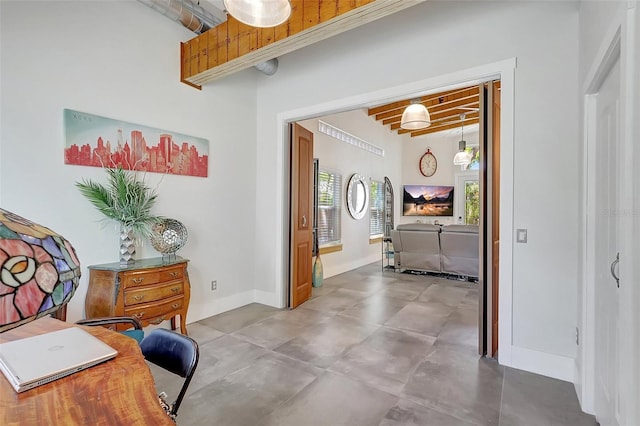 hallway with finished concrete flooring and baseboards