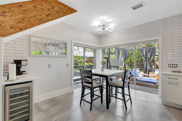 dining room featuring baseboards, visible vents, wine cooler, and a healthy amount of sunlight