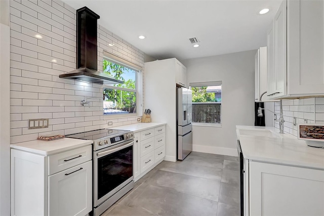kitchen with wall chimney exhaust hood, stainless steel appliances, tasteful backsplash, baseboards, and recessed lighting