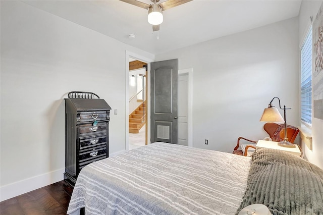 bedroom with ensuite bathroom, baseboards, ceiling fan, and dark wood finished floors