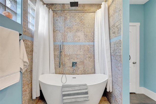 bathroom with a freestanding tub and curtained shower