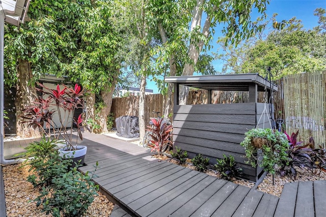 wooden deck with a fenced backyard