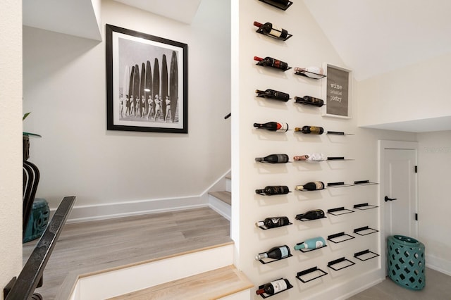 wine room with vaulted ceiling, wood finished floors, and baseboards