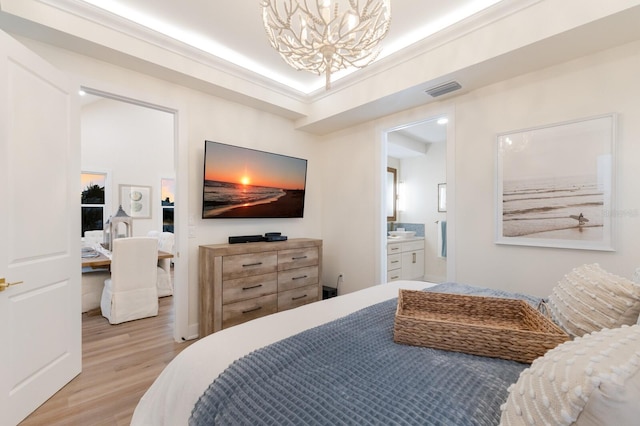 bedroom featuring visible vents, ensuite bath, light wood-style flooring, and ornamental molding