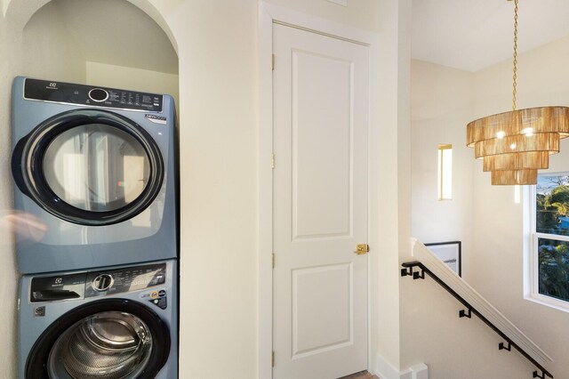 clothes washing area featuring laundry area and stacked washing maching and dryer