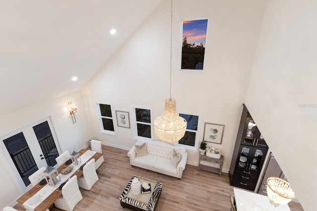 living area featuring baseboards, recessed lighting, high vaulted ceiling, and light wood-style floors